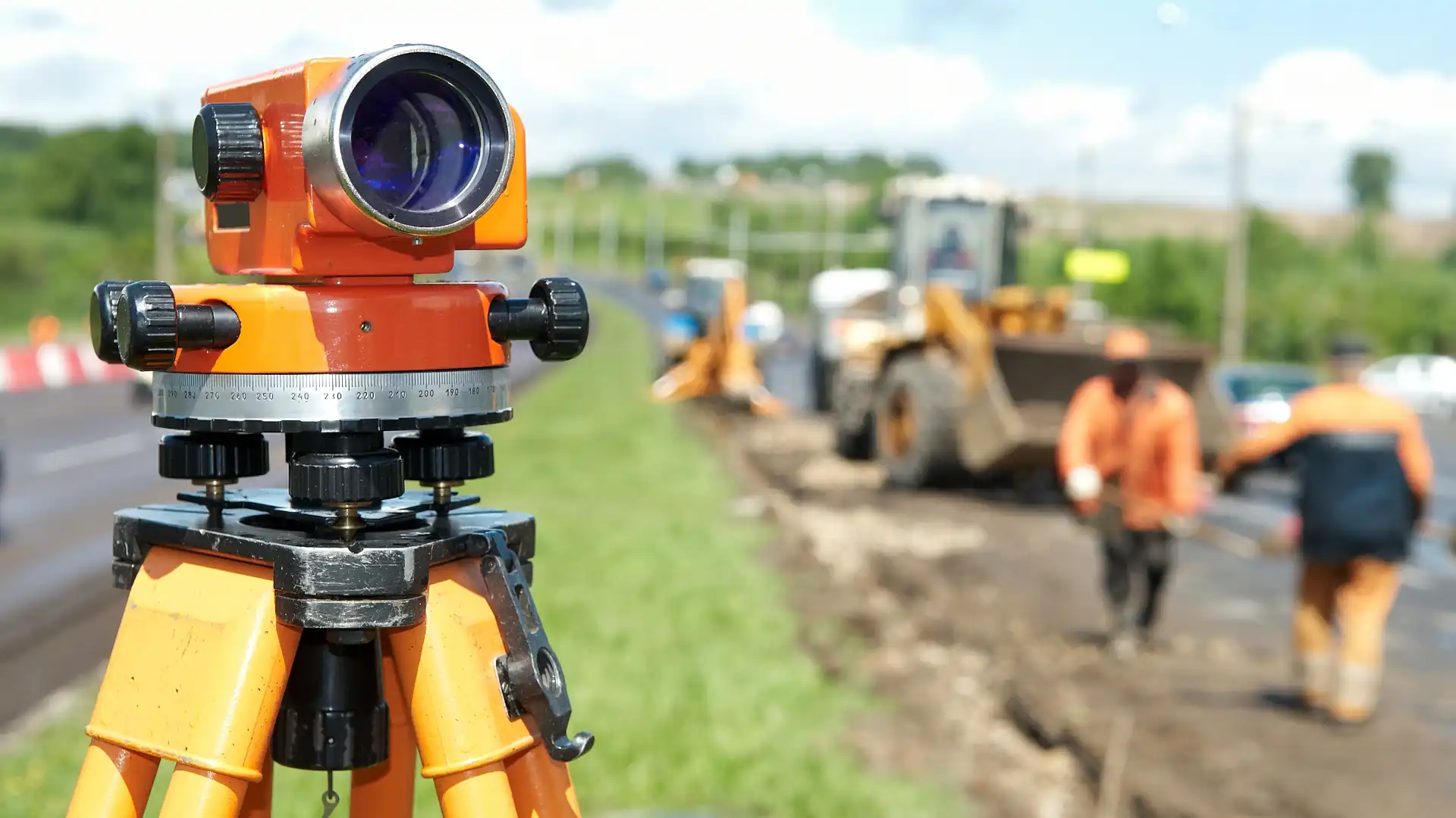 Topographic survey - Total station with construction workers in the background
