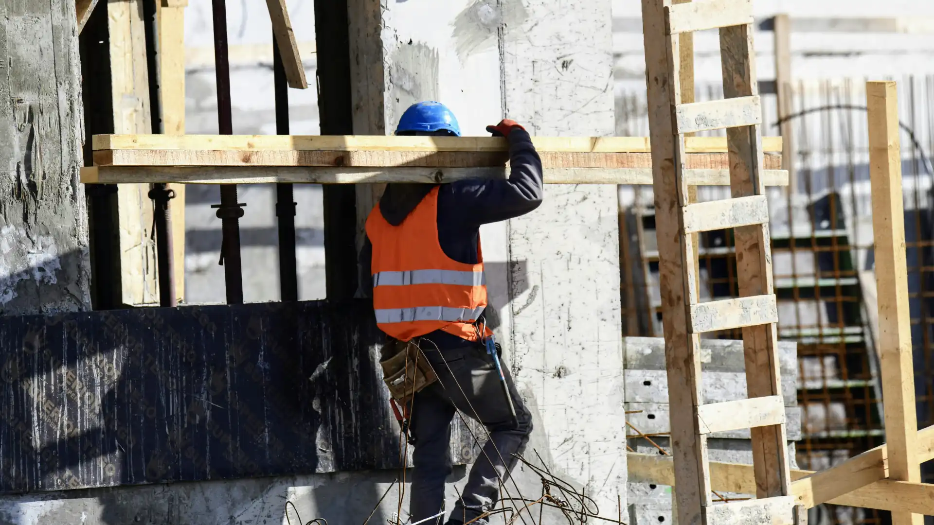 Construction worker carrying timber on shoulder - engineering approval