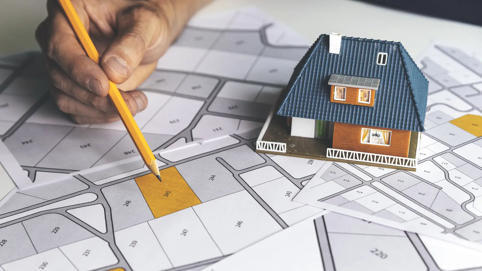 Surveyor reviewing a property plan with a model house - easements in NZ